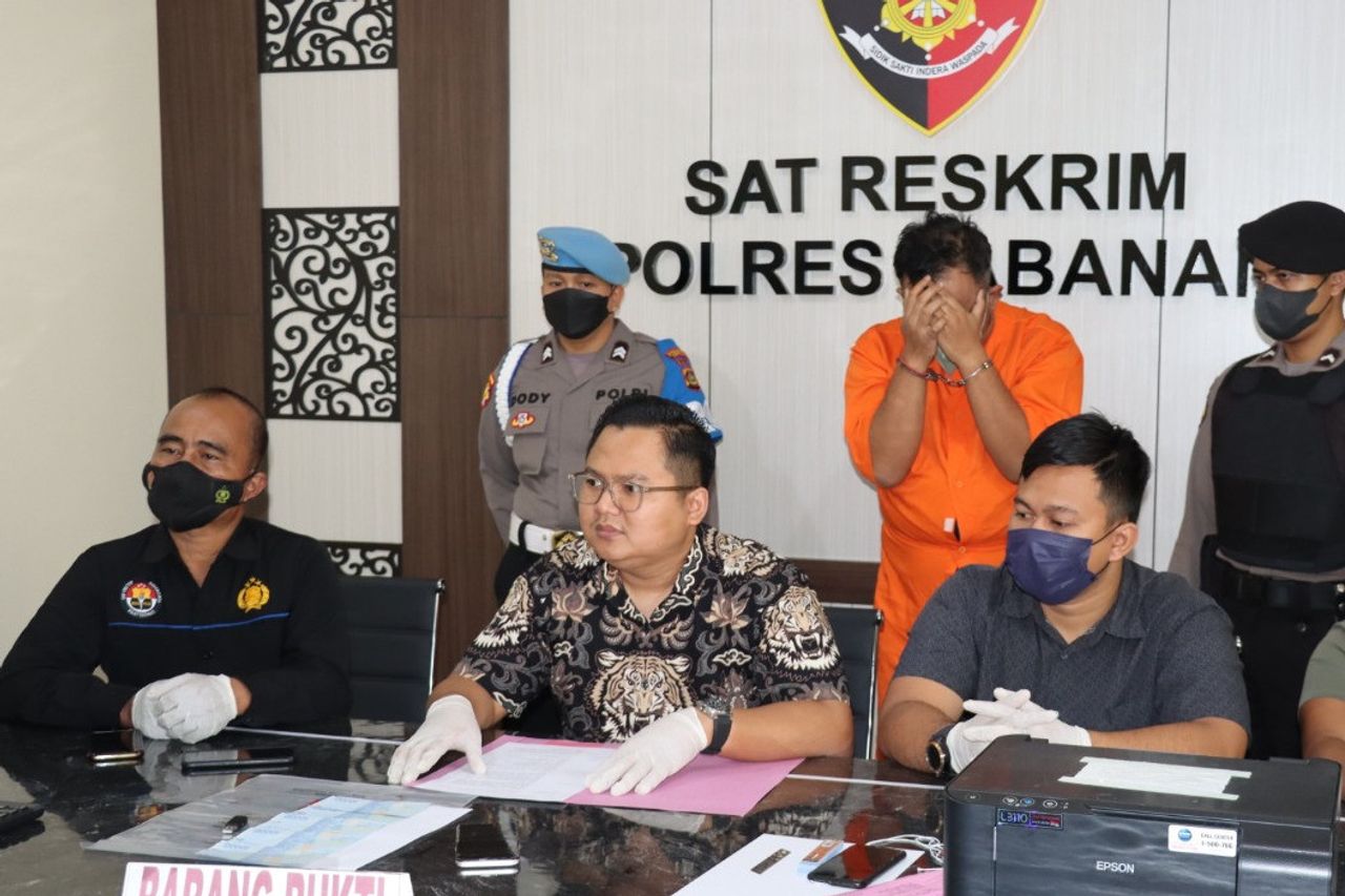 Cover Your Face With Hand Handcuffed, He Is A Doctor In Tabanan Bali Who Was Arrested By The Police For Paying A Driver To Mass Use Fake Money