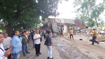 Les habitants de Duren Sawit démontrent un barrage de fer qui couvre un site d'enfouissement