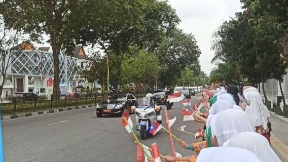 الترحيب بجوكوي أثناء مروره عبر بيكانبارو ، ورفعت صفوف من الطلاب العلم الأحمر والأبيض