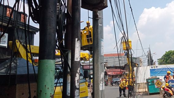Petugas Potong Kabel Udara Semrawut Milik 25 Operator di Lubang Buaya