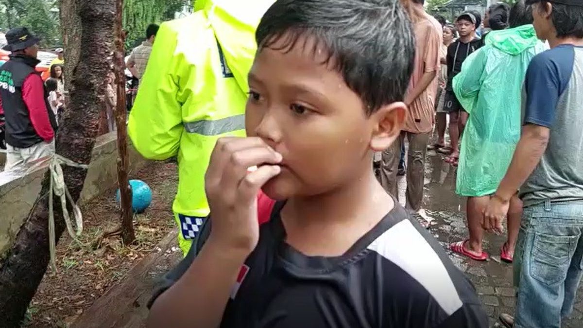雨の中でPJU電柱を持ち、ボール遊びをした後、彼の人生を伸ばす10歳の少年
