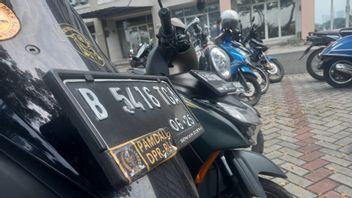 في مكتب الفائز بمجلس النواب الإندونيسي ستائر مناقصة بقيمة 4.3 مليار روبية هناك دراجة نارية مع ملصق من مجلس النواب الإندونيسي بامدال ، وثلاثة موظفين بداخلها