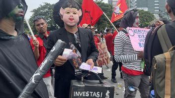 자카르타 노동절 시위대 직원들이 폭정을 선고하는 회사 상사의 유니폼에 돼지 가면을 쓰고 있다