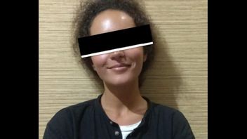 バリ島で偽の綿棒を運んだ容疑で逮捕された警察に微笑む女性