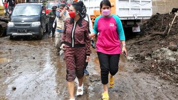 折りたたみズボン、クリスダアンティはマランで洪水の犠牲者を助けるために泥だらけの道を通過します