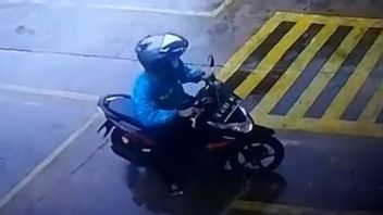 雨に見えつつ、2人の泥棒がアルファマートの従業員のオートバイを奪う道 