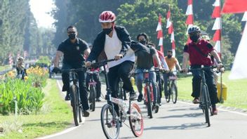 Ditemani Kaesang, Jokowi Bersepeda Sambil Bagikan Masker di Kebun Raya Bogor