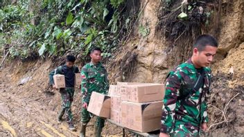 Soldats de l'armée de terre marchent à pied à travers une zone de glissement de terrain pour apporter des médicaments aux habitants