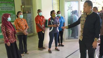 パプアニューギニア人にもサービスを提供するソタメラウケヘルスセンターの医療従事者に帽子をかぶる