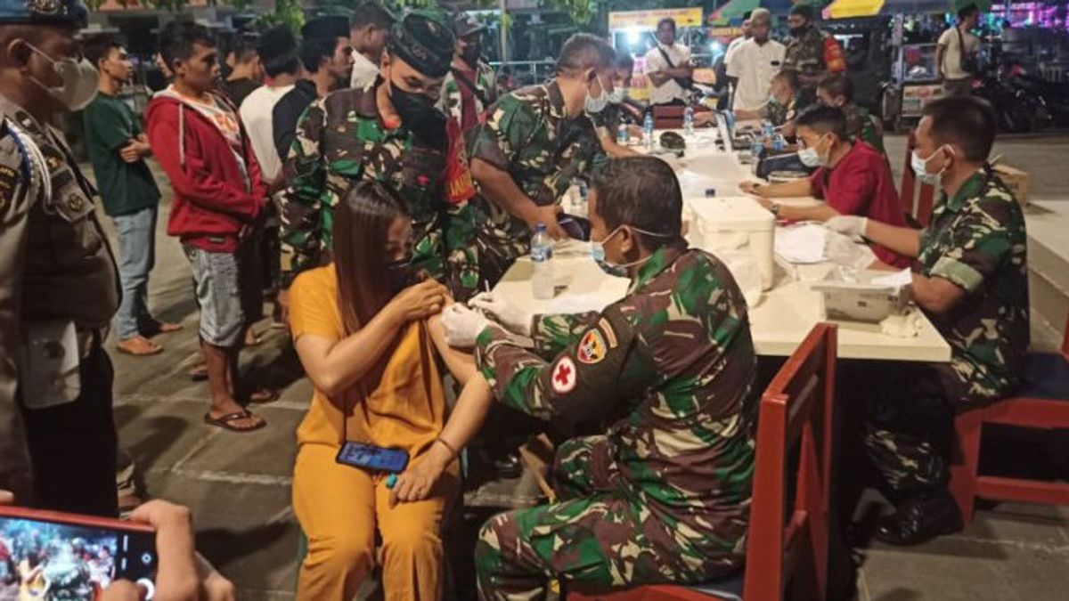 Tim Vaksinasi TNI-Polri Gelar Percepatan Vaksinasi pada Malam Hari di Pasar Jelojok