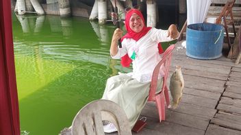 Une femme heureuse portant un Kebaya reçoit un poisson lors d'une course organisée à l'occasion du 79e anniversaire de l'Indonésie à Halim.