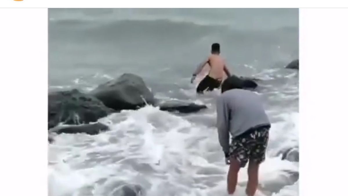 两名男子在马卡萨尔巴伦邦海滩的巨浪中游泳， 救援溺水青少年