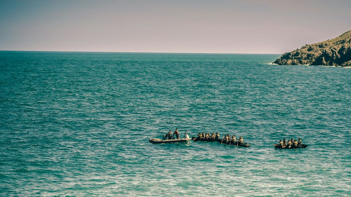 リビアで30人の不法移民を乗せたボートを追いかけ、1人が海に横たわっている