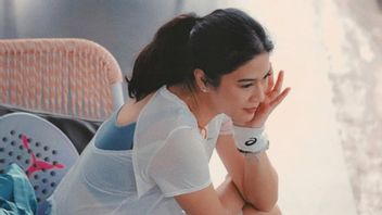 Portrait de Dian Sastro dans un terrain de padel avec un look sportif et élégant