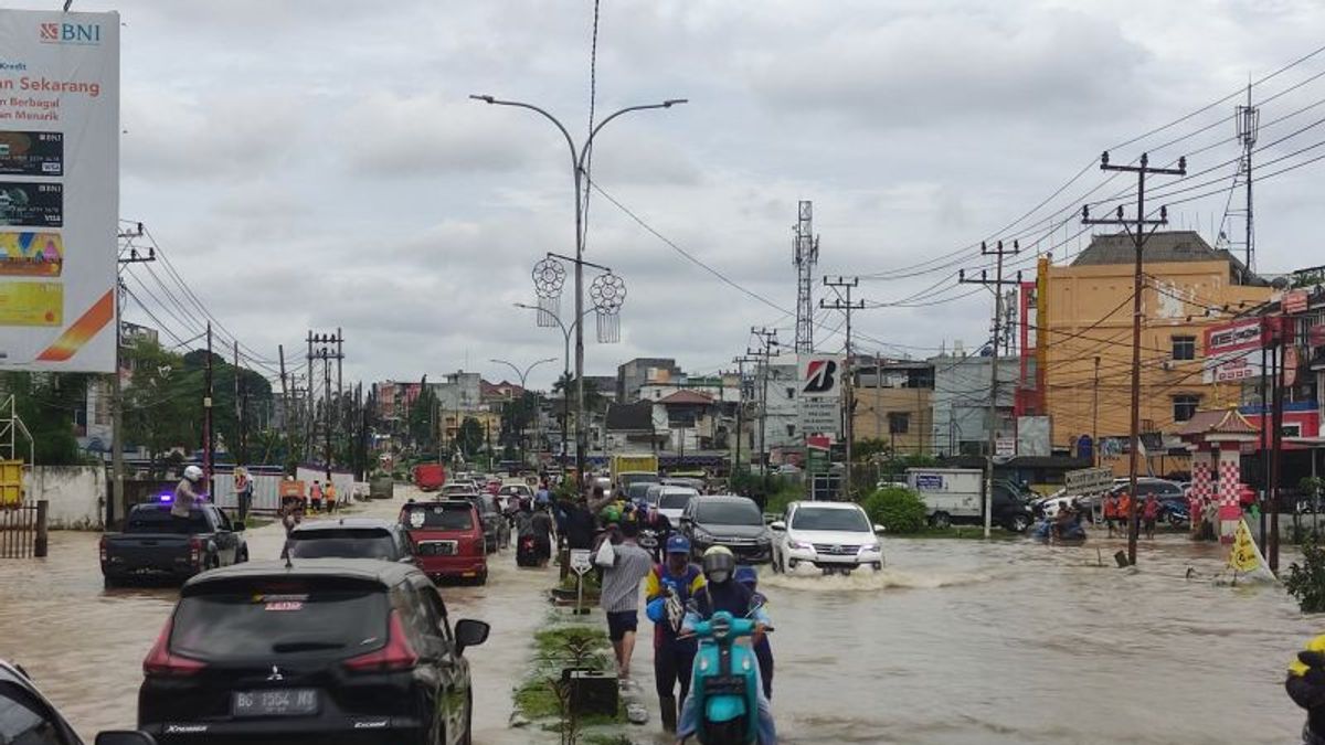 Jalan R Soekamto Palembang Sumselは60cmの水で浸水し、警察は交通渋滞を説明するために交通管理に忙しい
