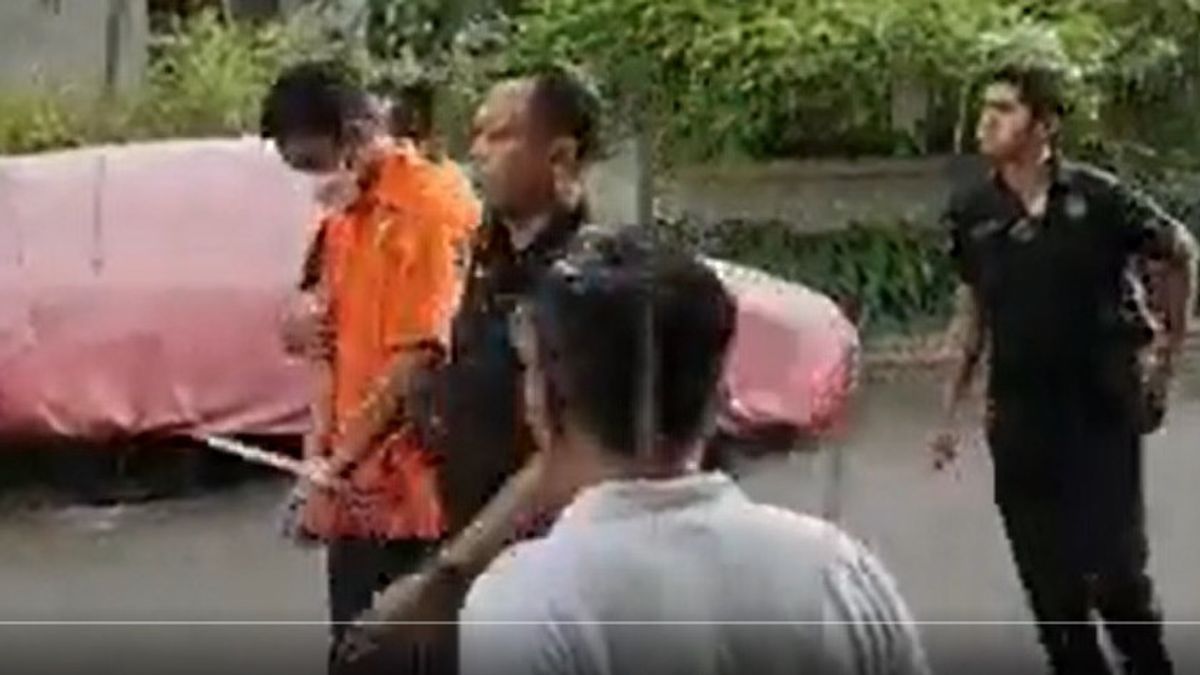 At The Reconstruction Location, Mario Dandy In Orange Clothes And Shorts, The Street Is Bowed Down, His Hands Are Tied Up