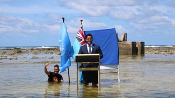 图瓦卢外长在海水中沉浸的海滩上发表演讲，展示气候变化的真正影响
