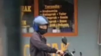 رجل فيروسي في منتصف العمر يؤدي عرضا على دراجة نارية على جانب الطريق