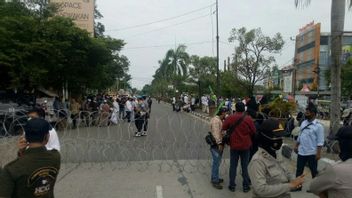 警察がパレンバンのハラウ群衆への道路を封鎖し、リジエック・シハブの釈放を要求
