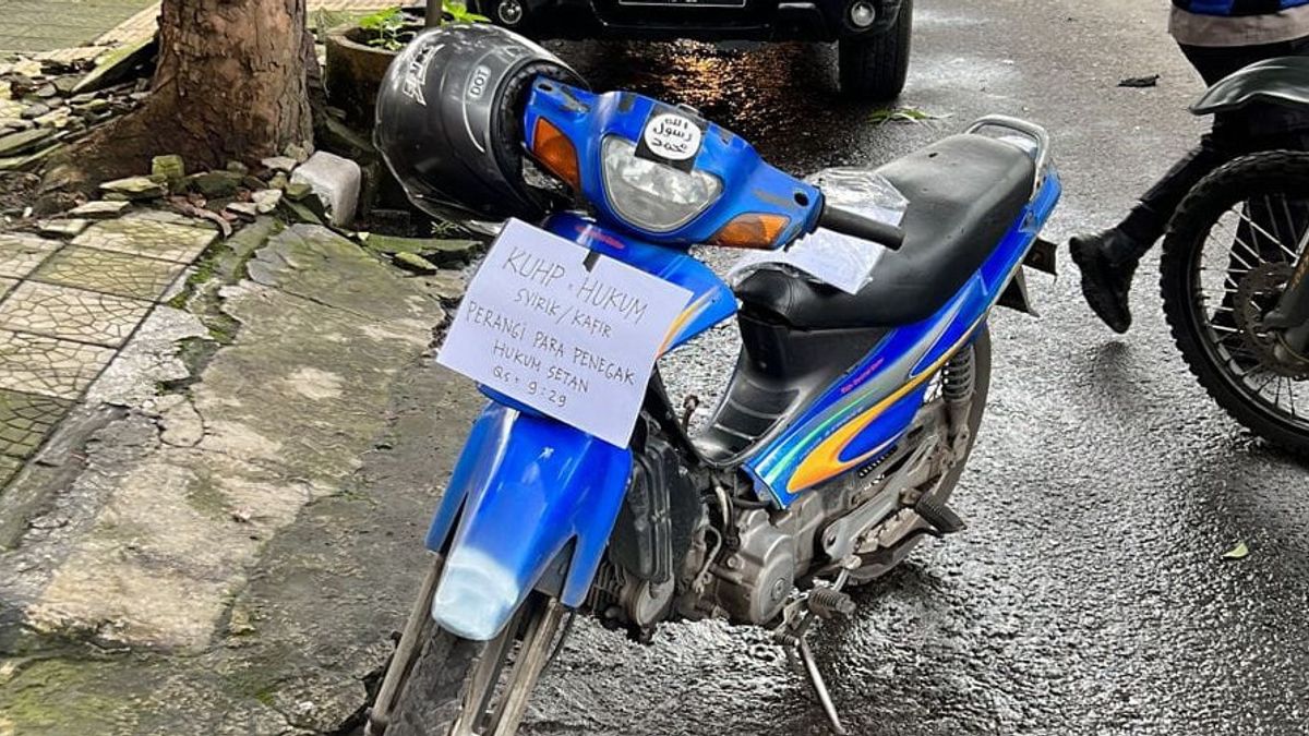 警方调查阿斯塔纳亚尔警察局附近写着“打击撒旦执法者”的蓝色铃木将军摩托车