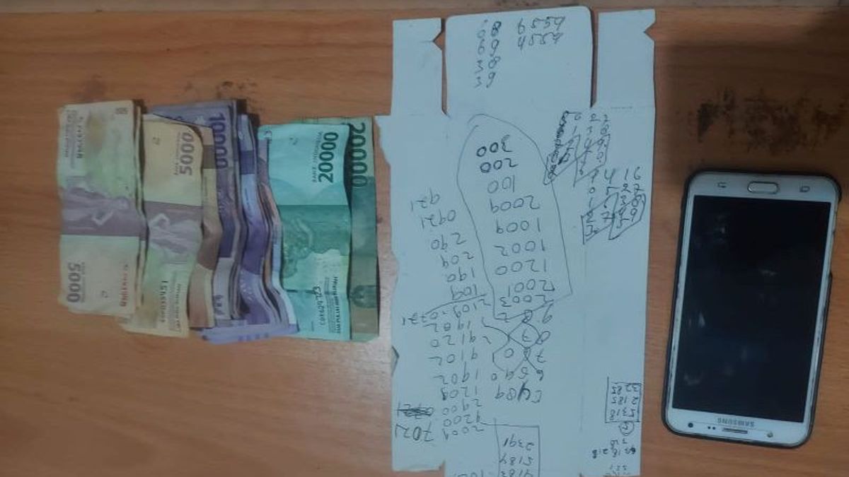 تلقي أرقام الطلبات للمراهنة على مواقع المقامرة عبر الإنترنت ، تم اقتياد بندر توجيل إلى مقر شرطة الساحل الغربي في لامبونج