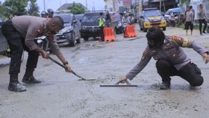 Salut! Cegah Kecelakaan Polisi ini Tambal Jalan Berlubang