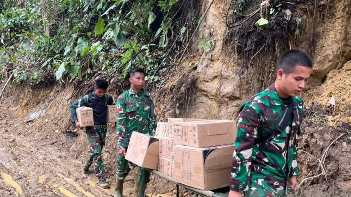 Soldats de l'armée de terre marchent à pied à travers une zone de glissement de terrain pour apporter des médicaments aux habitants