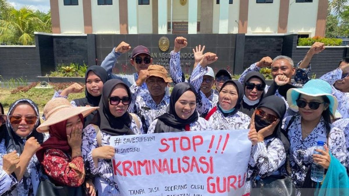 دعم سوبرياني خلال جلسة استماع في PN Andoolo ، وهو مدرس من PGRI Bentangkan Poster "Stop Kriminalisasi Guru"