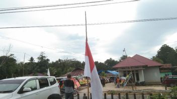 السكان يرفعون العلم الأحمر والأبيض في نصف الصاري يستقبلون ضحايا TNI من KKB بابوا