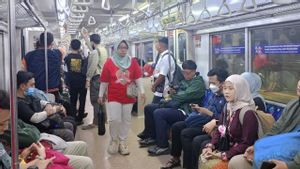 Penumpang Antusias Naik KRL Membawa Atribut Merah Putih Meriahkan HUT RI
