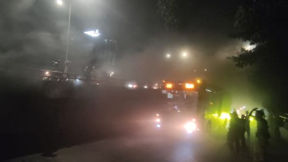 レボマーケットの高架道路のウッドパイルが燃え、車線が煙で覆われている