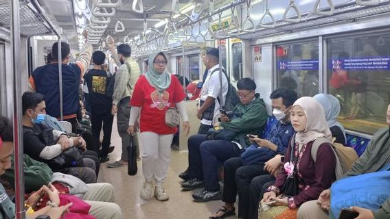 Penumpang Antusias Naik KRL Membawa Atribut Merah Putih Meriahkan HUT RI