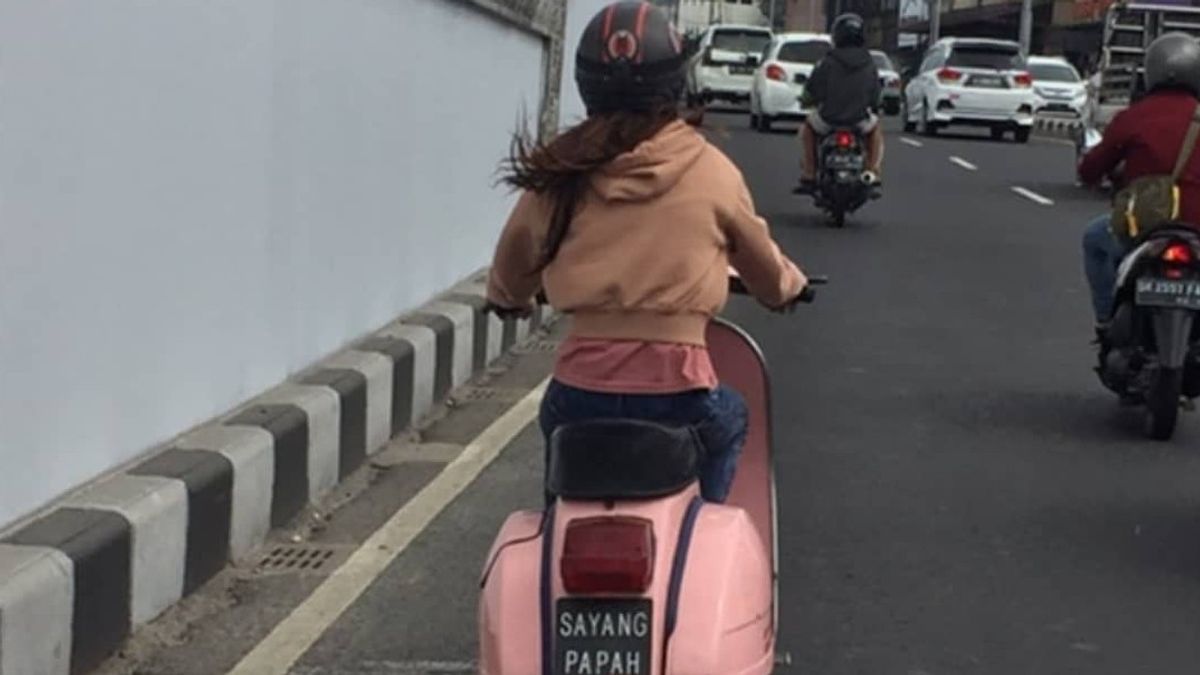 النساء الذين ركب فيسبا الوردي، مع لوحات أرقام "سايانغ باباه" في بالي، يصبح تسليط الضوء