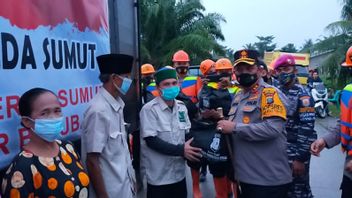 北苏门答腊巴图巴拉的洪水灾民可以微笑， 因为警察局长给食物包