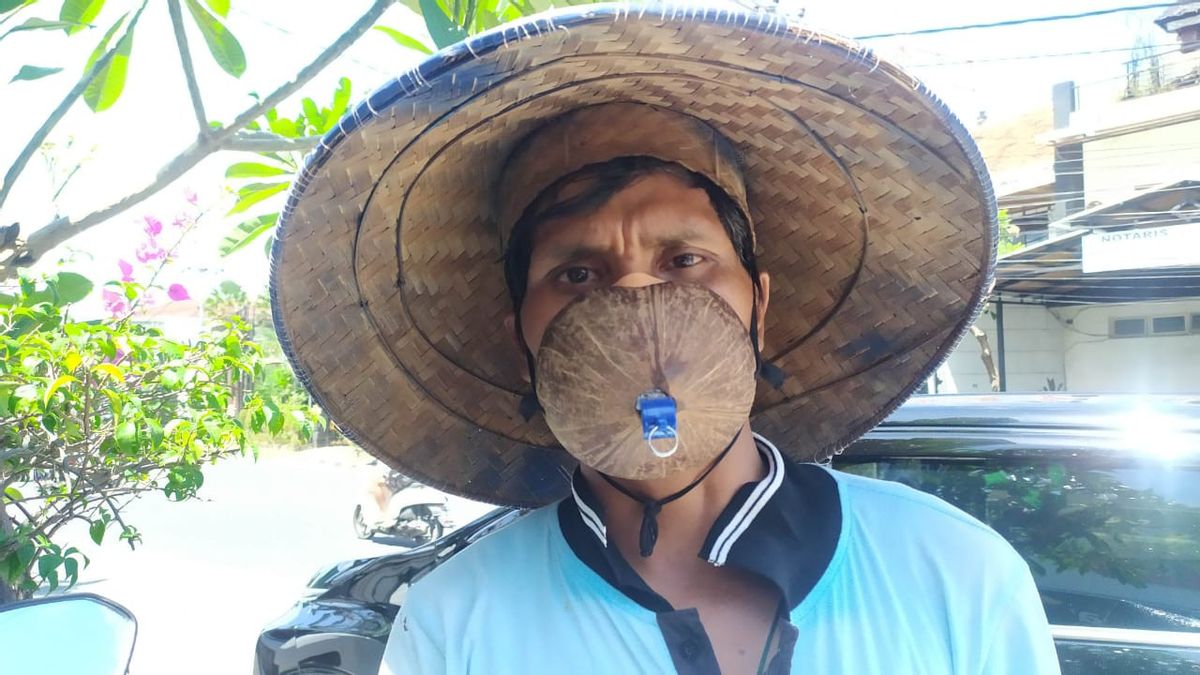 Un Préposé Au Stationnement Viral à Denpasar Bali Porte Un Masque De Coquille De Noix De Coco