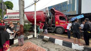 燃料油箱卡车的司机Pertamina Banting Setir,因为有一辆摩托车突然在红灯处停下